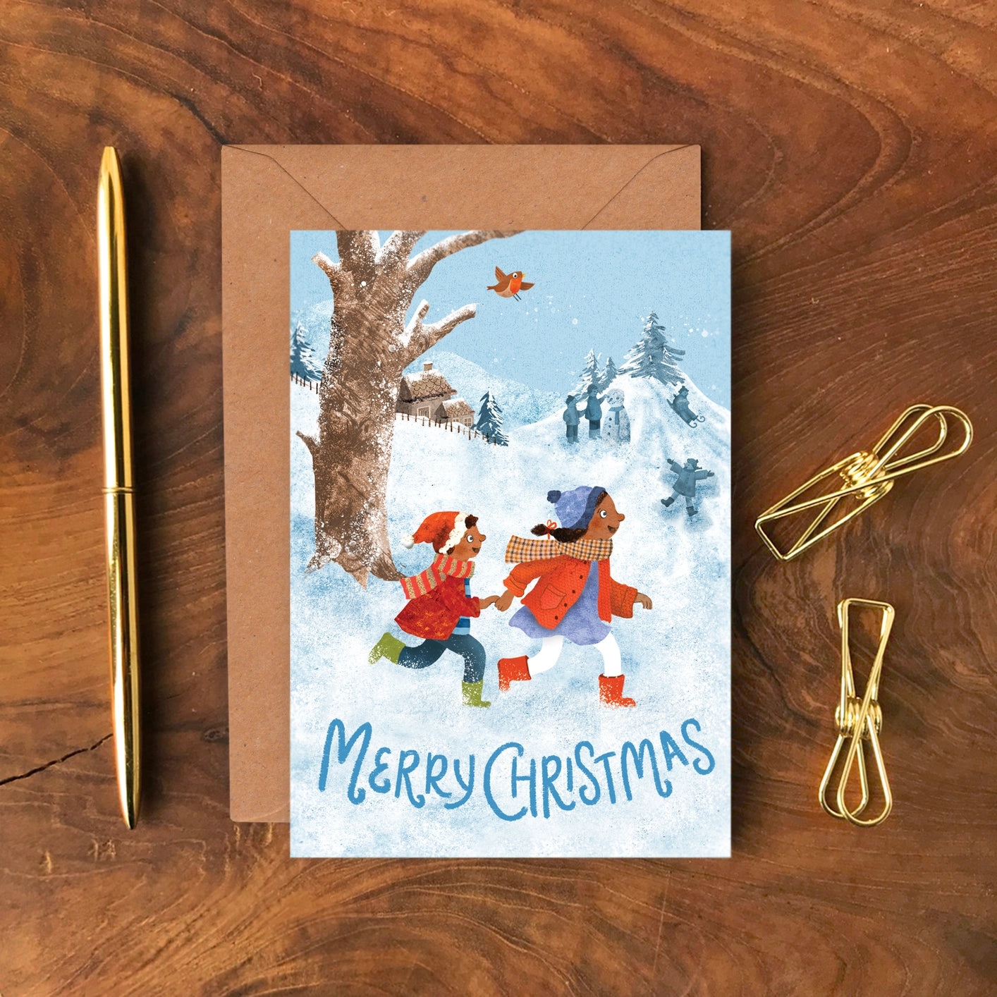 A6 Christmas card featuring an illustrated wintry street scene with people walking through snow, designed by Emily Nash, printed on eco-friendly matte card with kraft envelope.