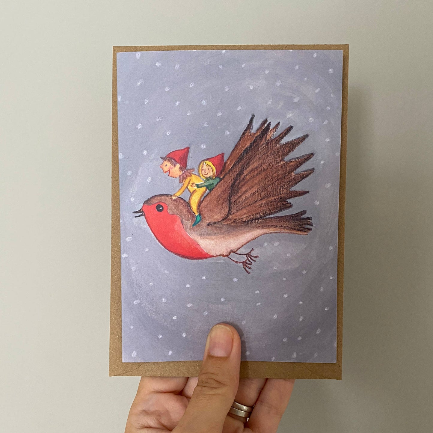 Illustrated card of Elves riding a Robin Yo ho ho. These elves are all dressed up for winter having the time of their life riding a robin across the snowy sky.