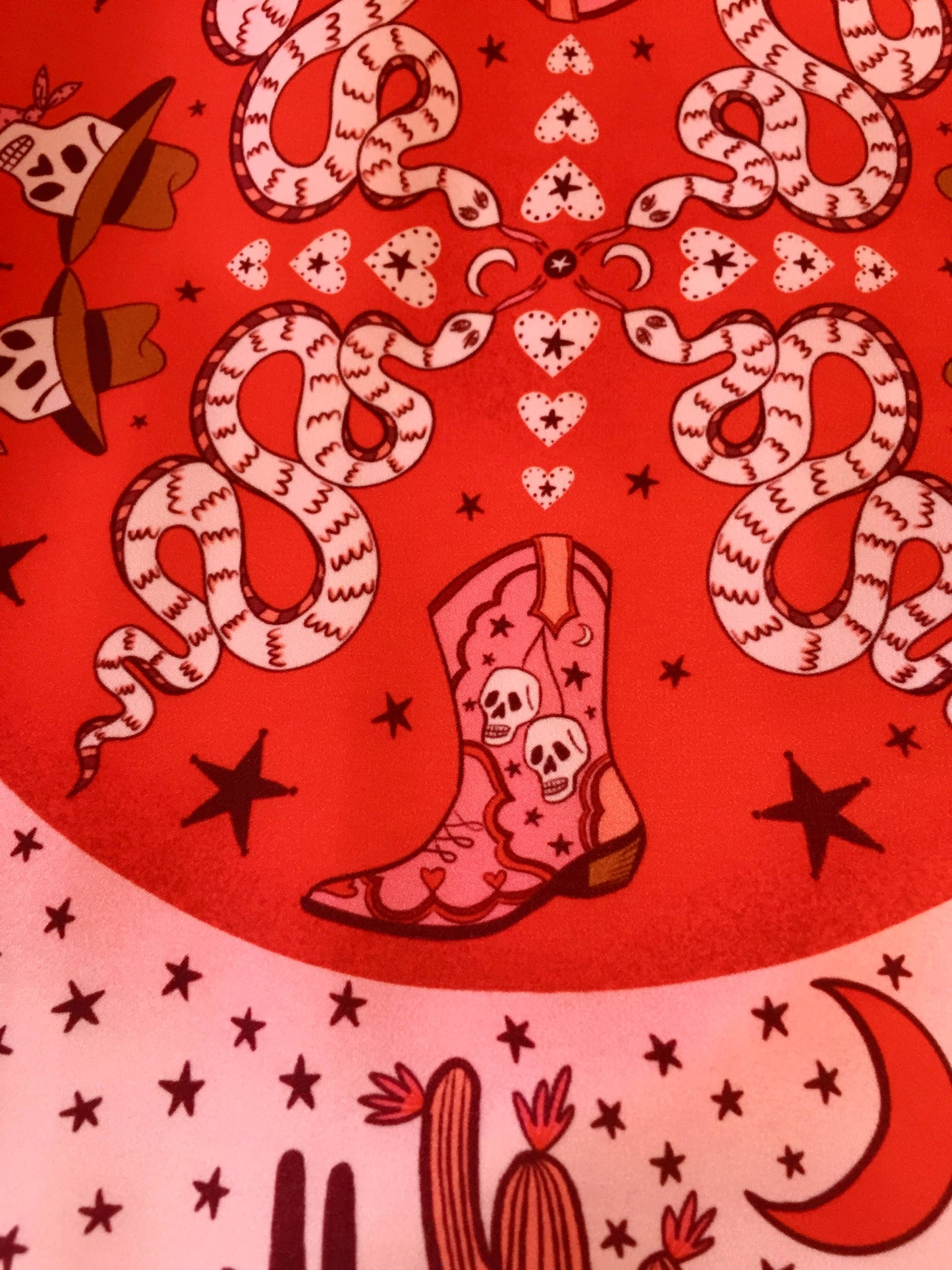 Eco silk twill pocket square with sassy cowgirl and white stallion, cacti, stars, boots, snakes, mountains, and horseshoe border in red and pink. Made from recycled polyester, designed by Su Owen.