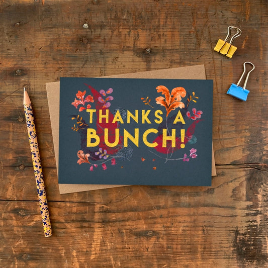 Thanks a bunch in bold capitals in yellow. Thank You greeting card with a simple and colourful illustration of flowers against a black background.