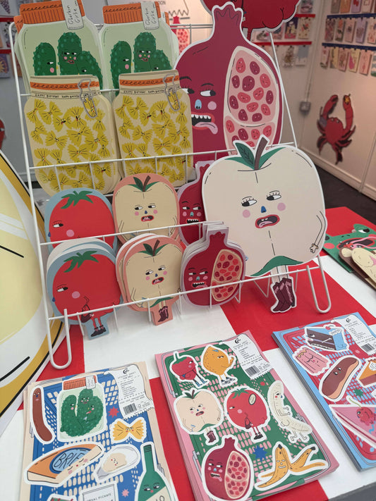 Playful display of colourful children's vinyl stickers featuring cartoon fruits and vegetables, arranged on a light surface