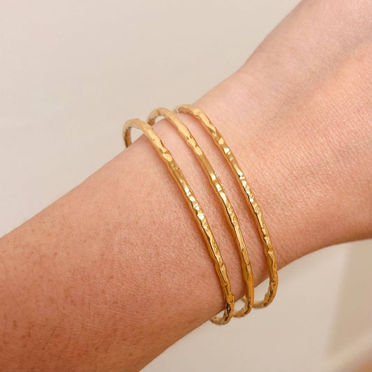 Model wearing the Hammered Trio 18k Gold Plated Bangle on wrist, styled with other jewellery