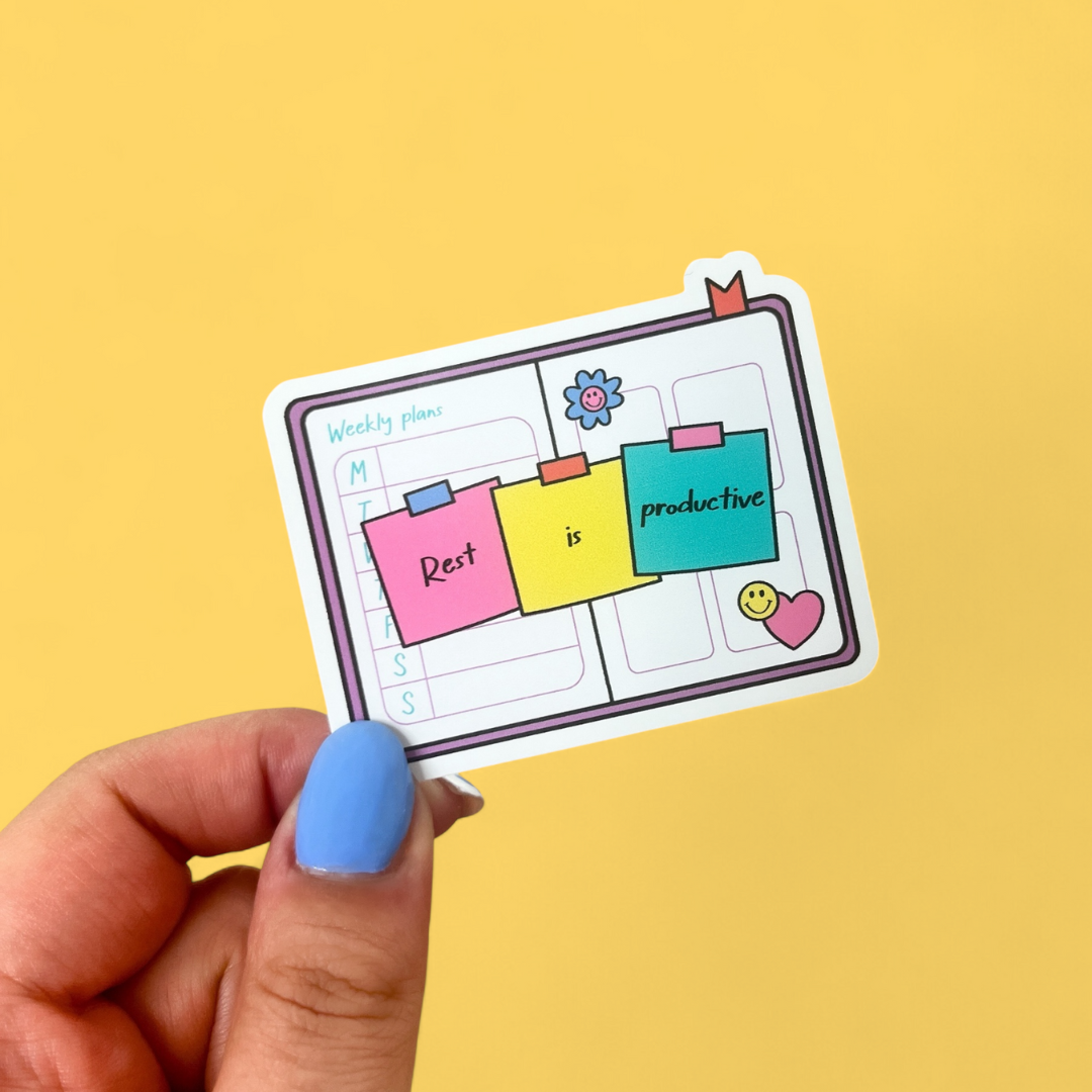 Close up of Rest Is Productive waterproof sticker on a journal