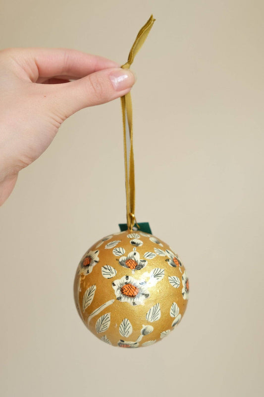 Close-up of Hand-Painted Gold & White Papier Mâché Bauble