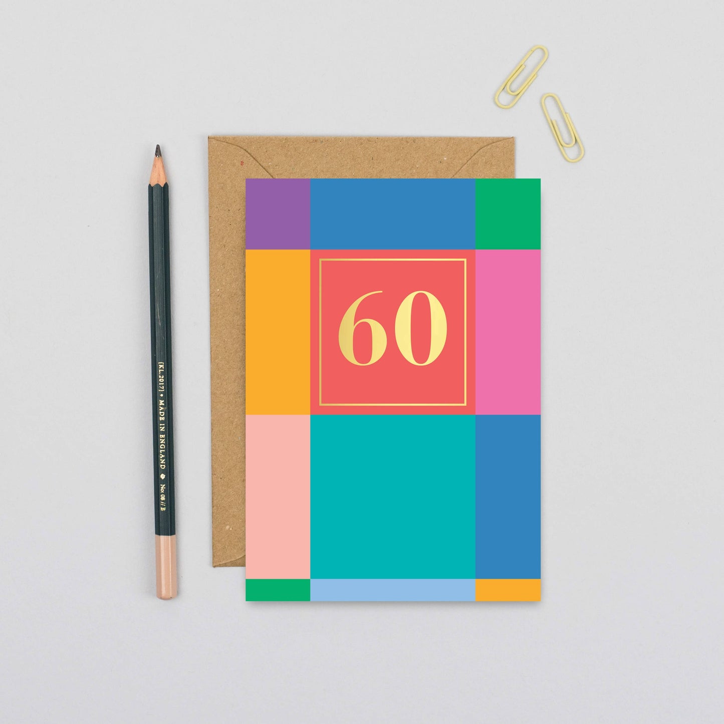 Vibrant 60th birthday card with colourful blocks and gold foil '60' detail, paired with a recycled kraft envelope.