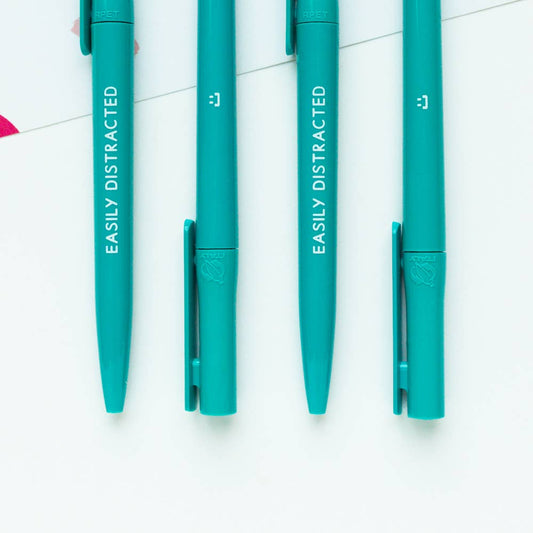 Close-up of a turquoise recycled plastic ballpoint pen, 'Easily Distracted' inscription, smooth black ink.