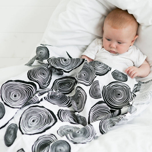 Close-up of baby interacting with GOTS organic cotton high-contrast fern print muslin