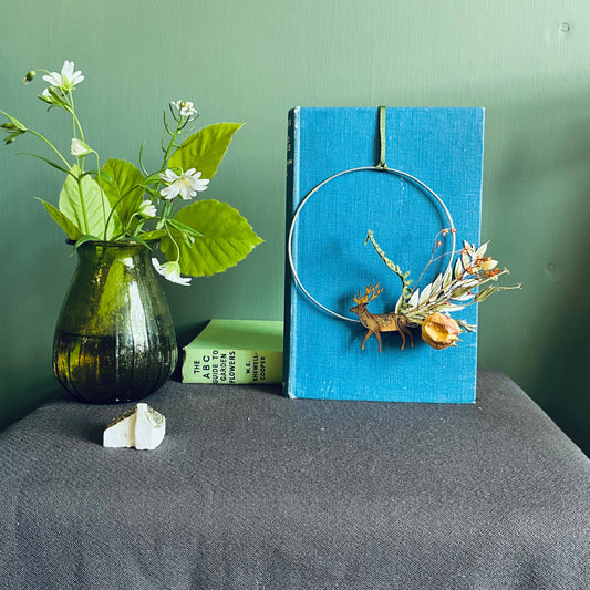 Close-up of the hand-painted wooden stag detail on a decorative wreath