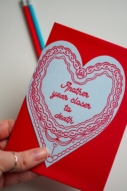 Close-up of letterpress printed funny birthday card with red envelope
