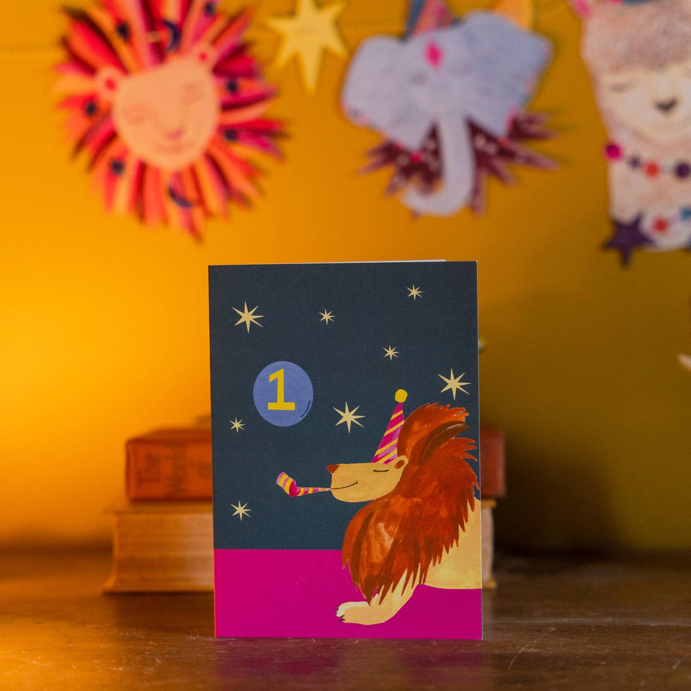 Hand-illustrated ‘Party Lion’ Age 1 birthday card, lion in party hat with blower, 5x7”, recycled kraft envelope, UK made, sustainable.