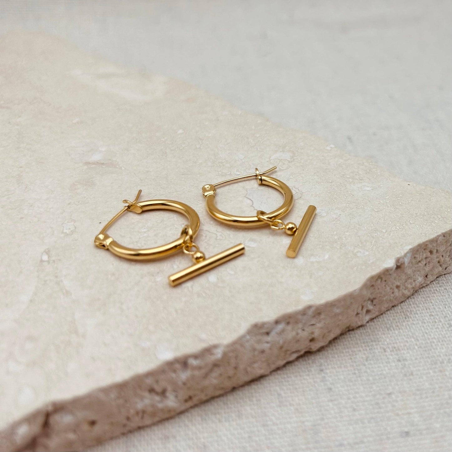 Pair of Little Nell lightweight gold bar hoops with removable charm, waterproof and hypoallergenic