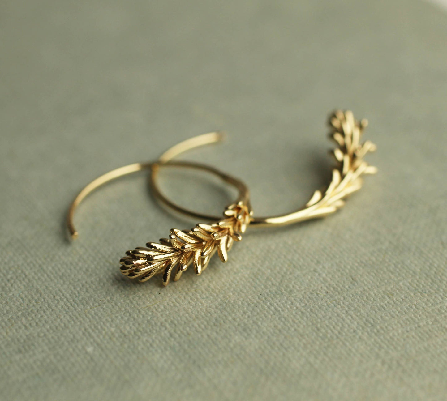 These rosemary leaf hoop earrings are made from plated brass with some amazing detail on the leaves. They feature a detailed botanical sprig of leaves, in a choice of gold. The hoop earrings measure 30mm in diameter and come with butterfly earring backs for a secure fit.
