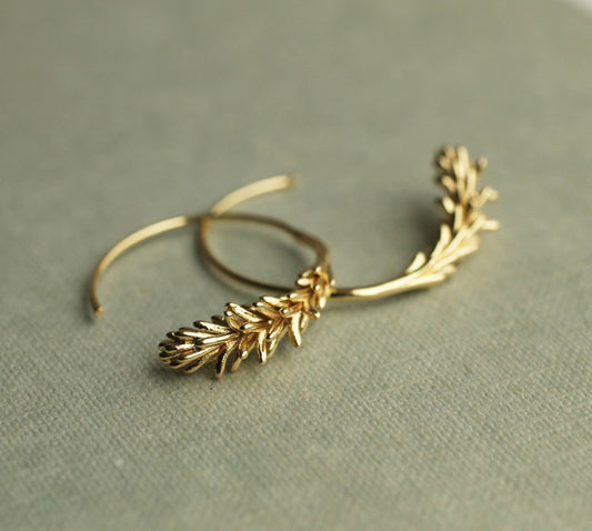 Pair of gold rosemary leaf hoop earrings displayed flat, showing their 30mm diameter.