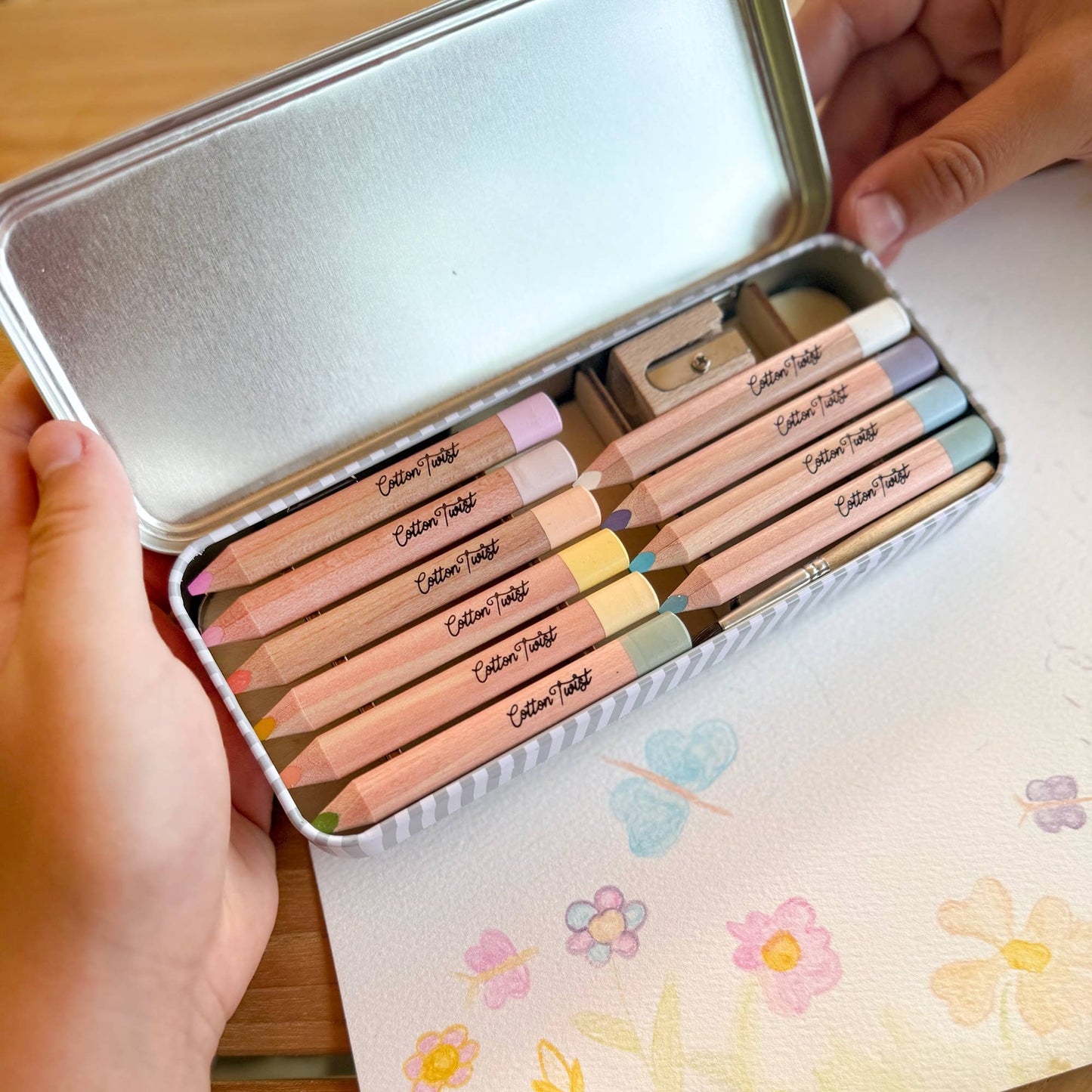 Cotton Twist Pastel Watercolour Pencils Set open tin with pencils, paintbrush, and sharpener.