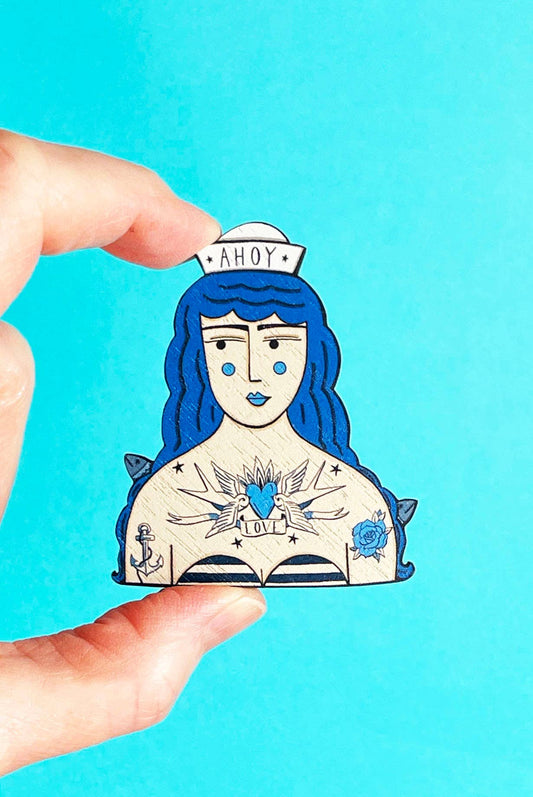 Close up of the sustainably sourced walnut wood texture on the sailor girl pin