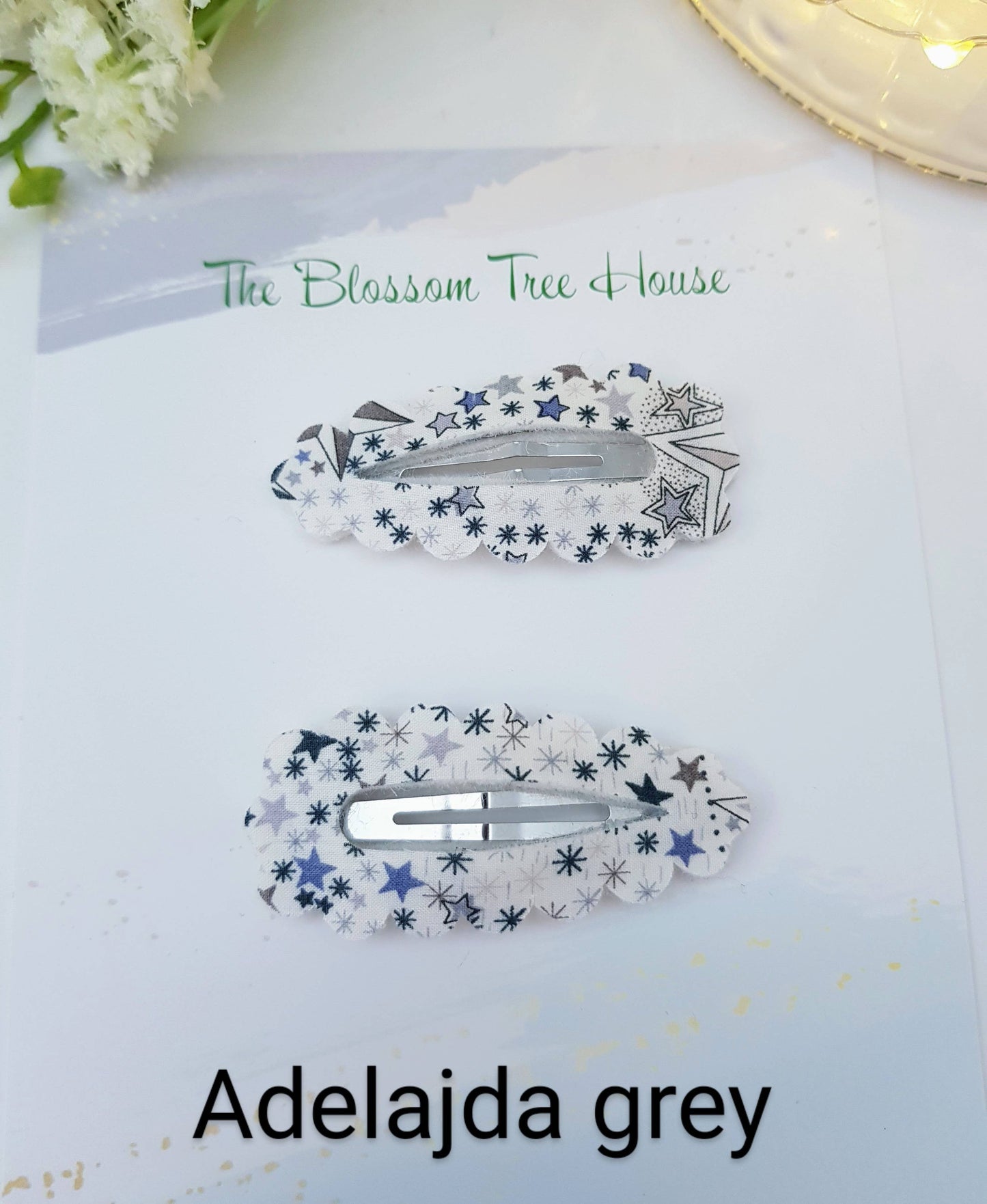 Two hair clips with star pattern on a card with 'The Blossom Tree House' branding.
