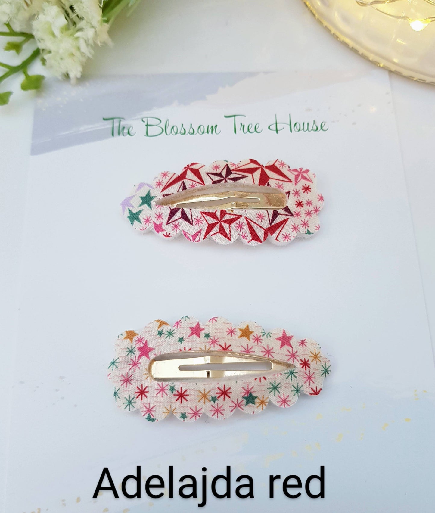 Two star hair clips on a white surface with 'The Blossom Tree House' branding.