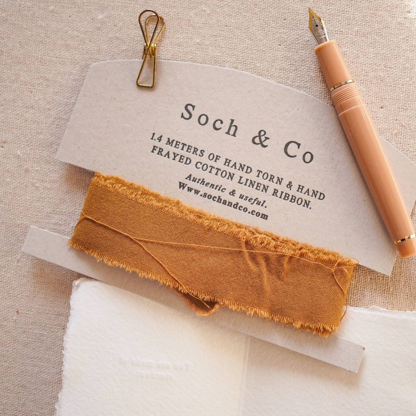 Hand-frayed linen ribbon in a vibrant colour, coiled on a sustainably sourced luxury backing card, ready for gifting.
