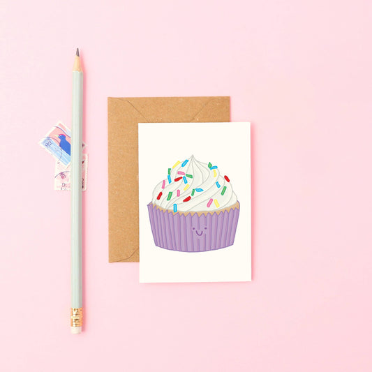 Close-up of Mini Cupcake Card with smiling cupcake, sprinkles, and purple case. Sustainably printed birthday or thank you card.