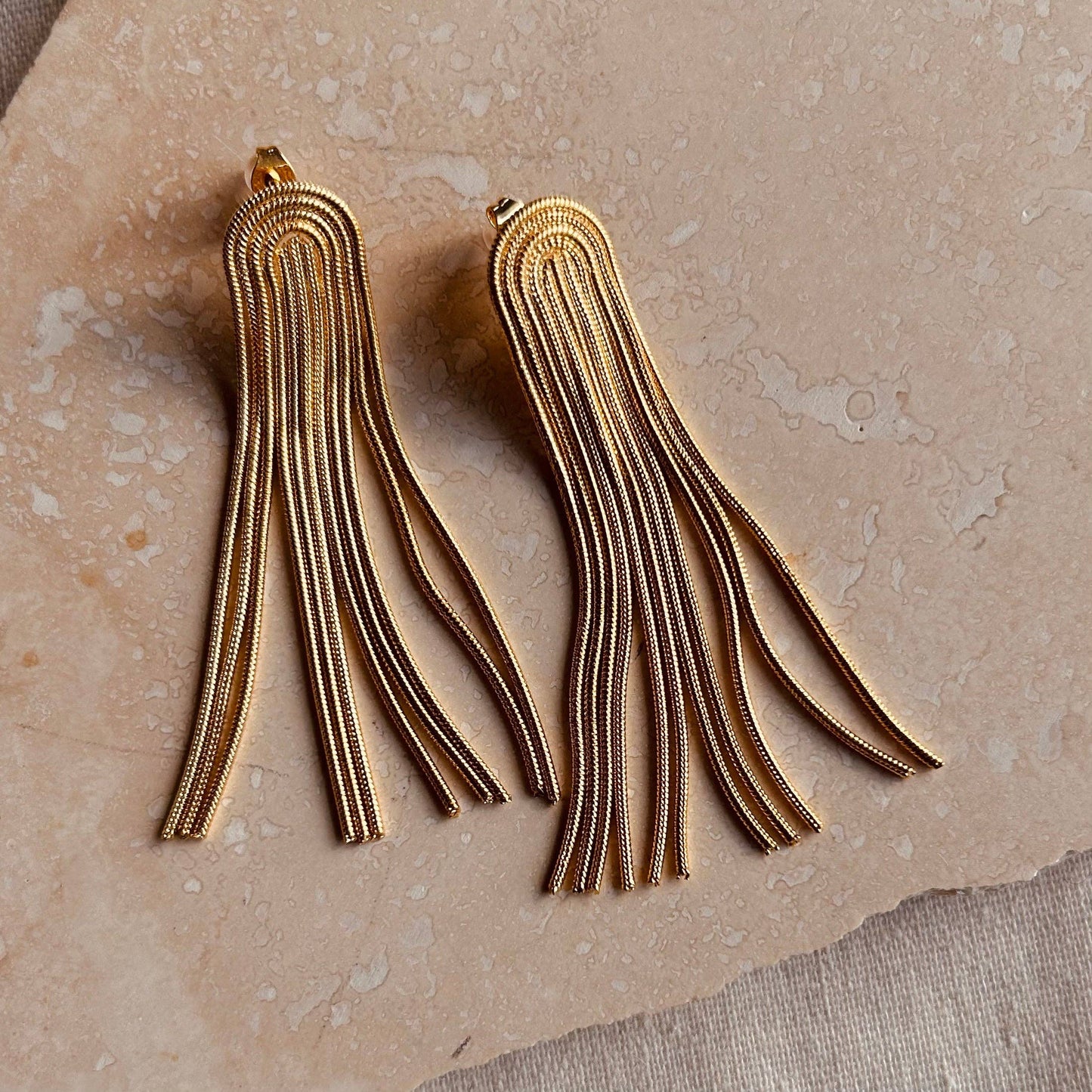 Close-up of Little Nell Arc Tassel Earrings, hypoallergenic gold jewellery