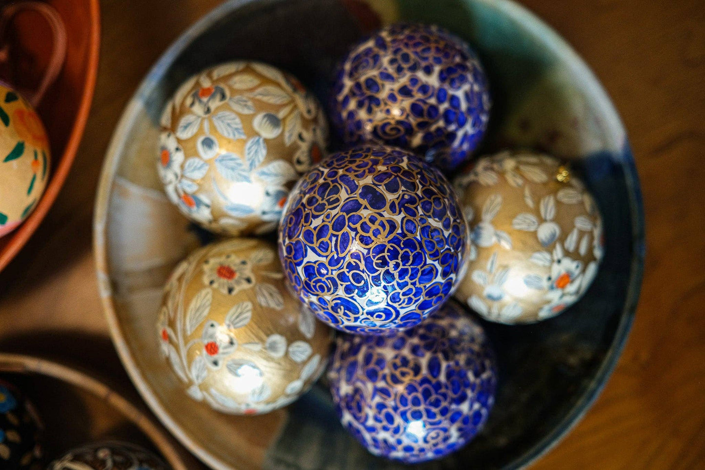 Hand-painted Gold and White Bauble by East End Press made of recycled papier mâché with velvet hanging loop