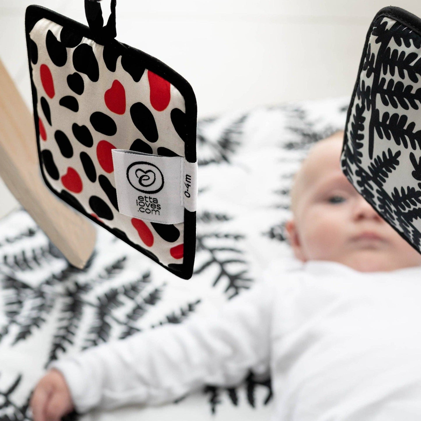 Triple pack of Etta Loves sensory hanging squares in fern/sycamore, chequers/illusion, and dalmatian/mirror designs, approx 13cm, with sensory features and velcro attachments.