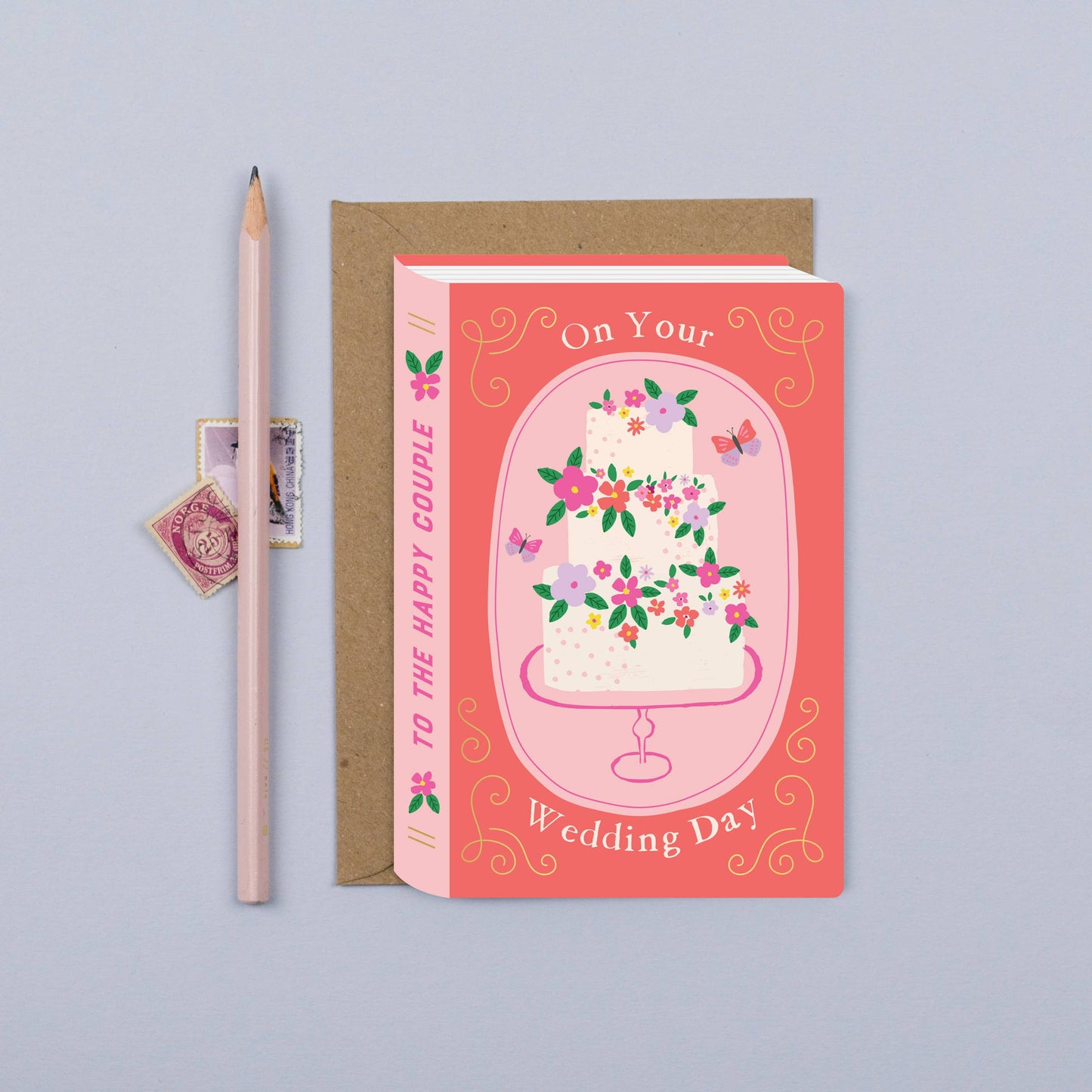 Fairytale Wedding Cake Book Card with delicate flowers and 'On Your Wedding Day' text, paired with a kraft envelope