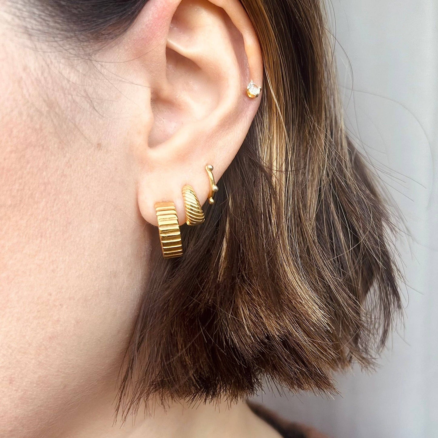 Stella gold hoop earrings in use, classic and modern, Little Nell jewellery.
