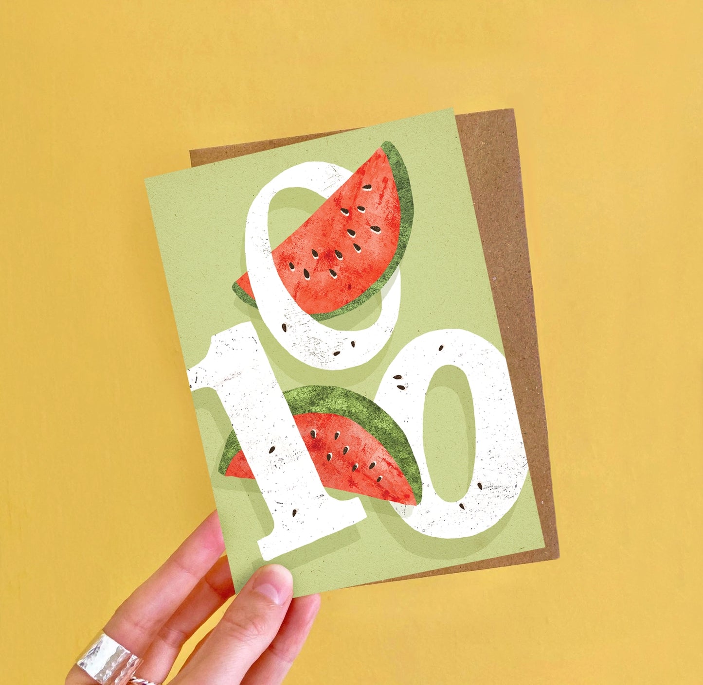 A6 100th birthday card featuring a colourful watermelon-themed illustration and ‘One Hundred’ caption by Emily Nash, printed on premium matte card with kraft envelope.