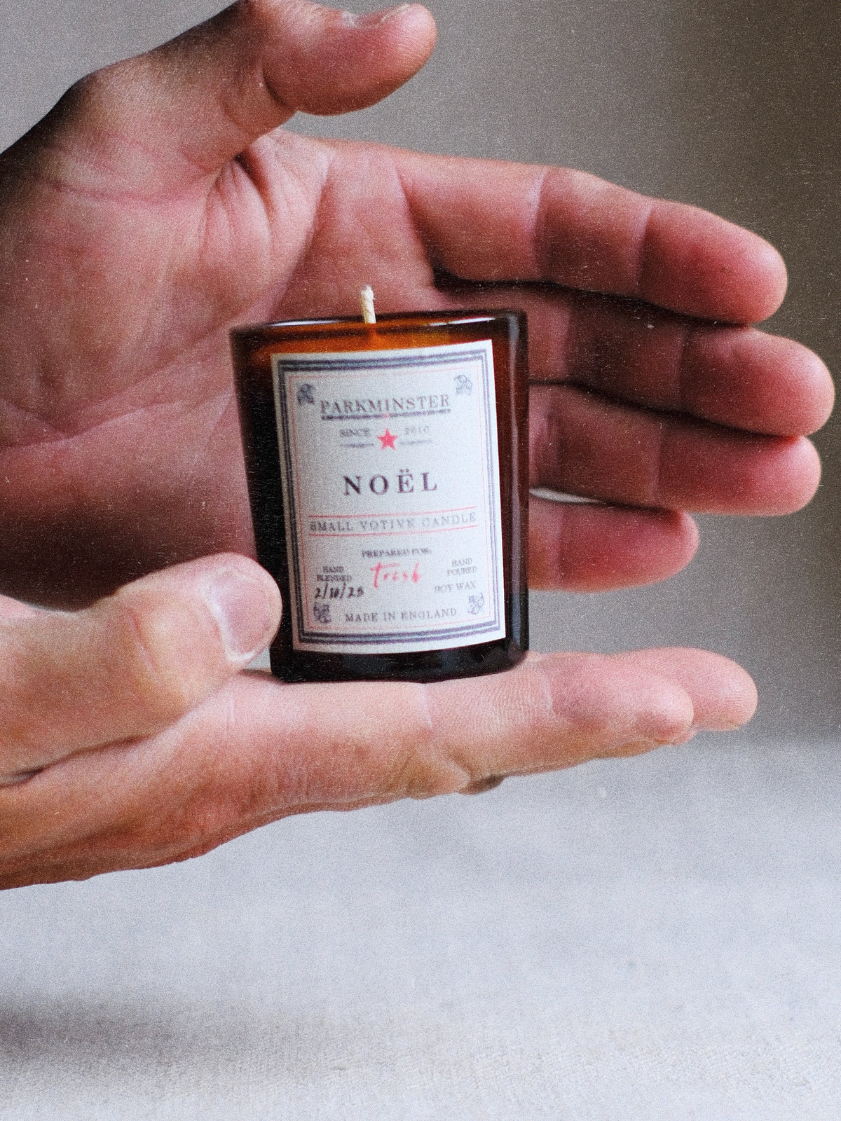 Close-up of Parkminster Noel Votive Candle glowing, showing soy wax and recyclable glass