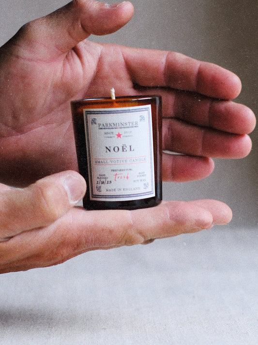 Close-up of Parkminster Noel Votive Candle glowing, showing soy wax and recyclable glass
