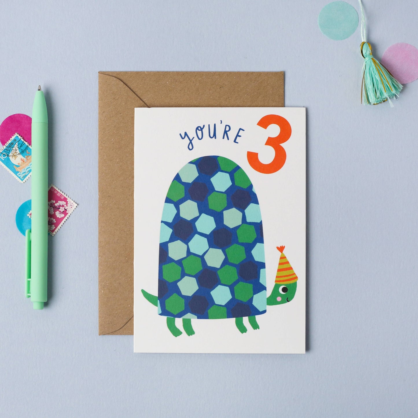 Age 3 birthday card featuring a cute blue and green turtle in a party hat with gold foil details, paired with a kraft envelope.