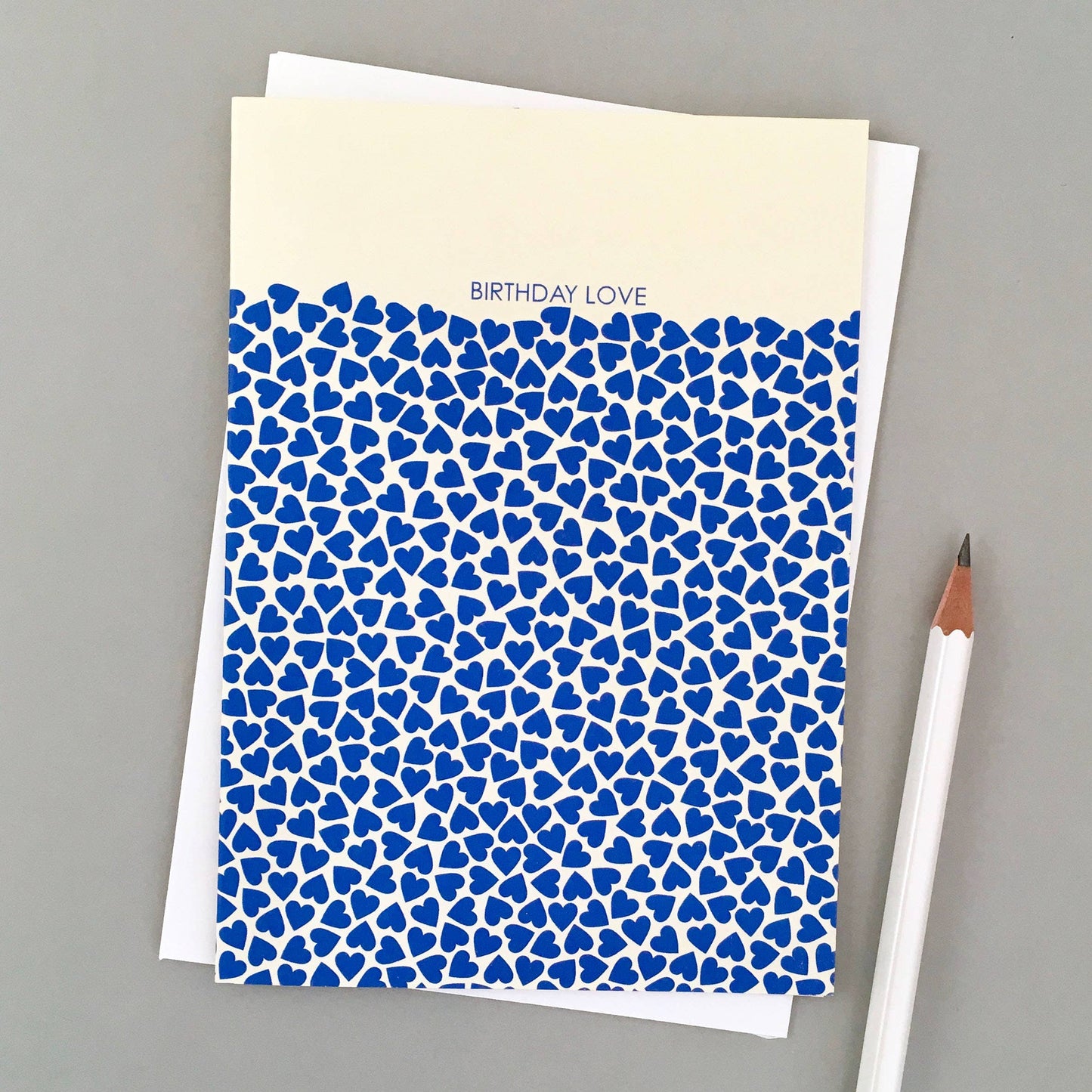 Birthday greeting card with overflowing hearts design, printed on sustainable 350gsm matt card, paired with a cream envelope and bio cello wrap