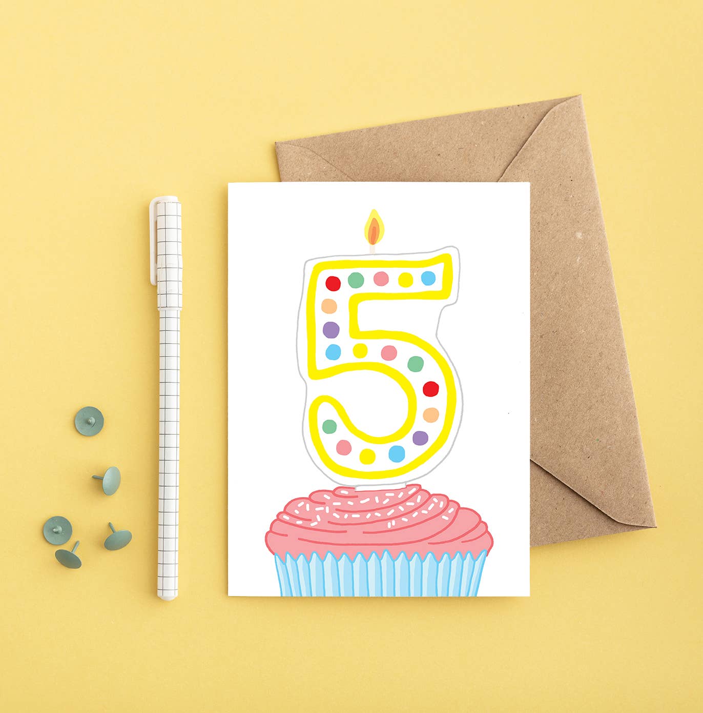 Brightly coloured cupcake 5th birthday card with a number 5 candle, shown with a Kraft envelope