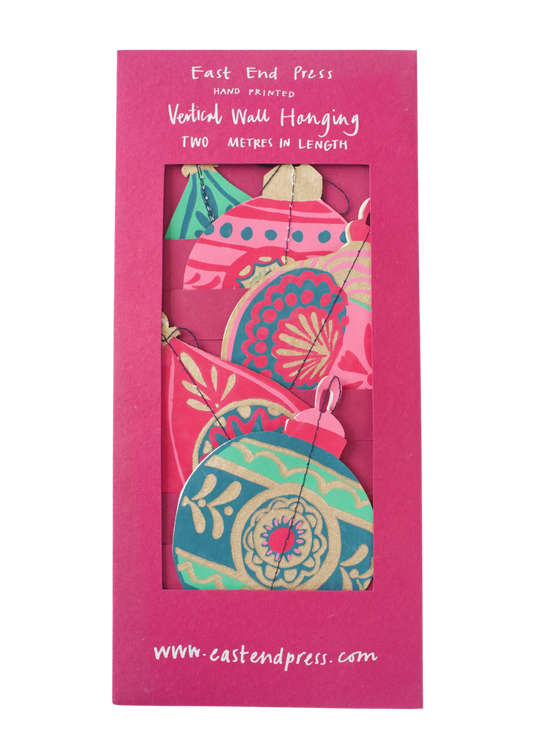 Bauble Vertical Wall Hanging Sustainably Made. The East End Press two-metre-long Bauble Vertical Wall Hanging features screen-printed festive shapes, and is printed double-sided on thick, handmade cotton paper. Pinks and Greens.