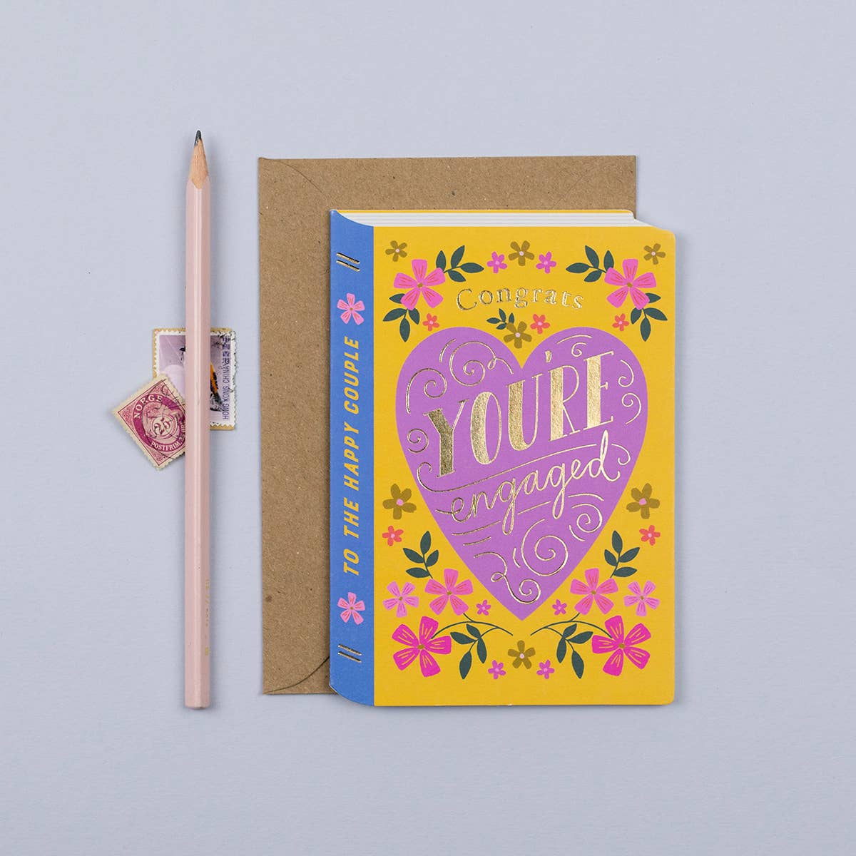 Sustainably sourced storybook engagement card with gold foil 'Congrats, You're Engaged' text and floral design.