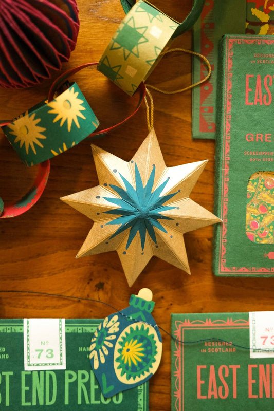 Close-up of hand screen-printed golden star recycled board decoration