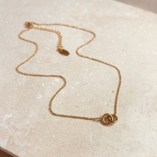 Model wearing a delicate gold plated double circle necklace, showcasing its size and style
