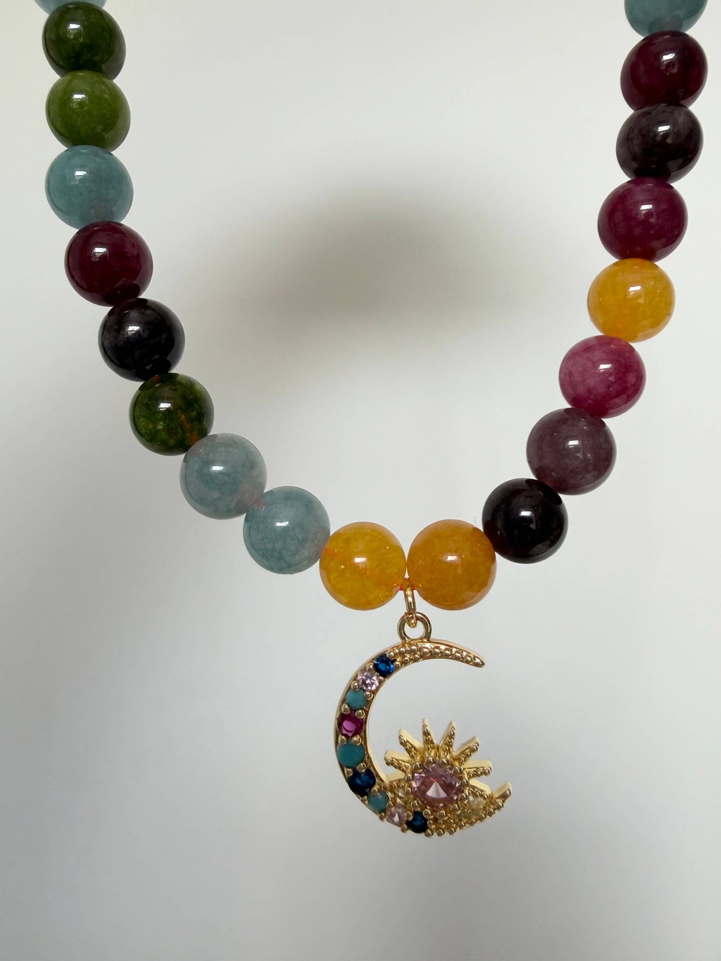 Close up of 18k gold plated moon charm with cubic zirconias on tourmaline necklace