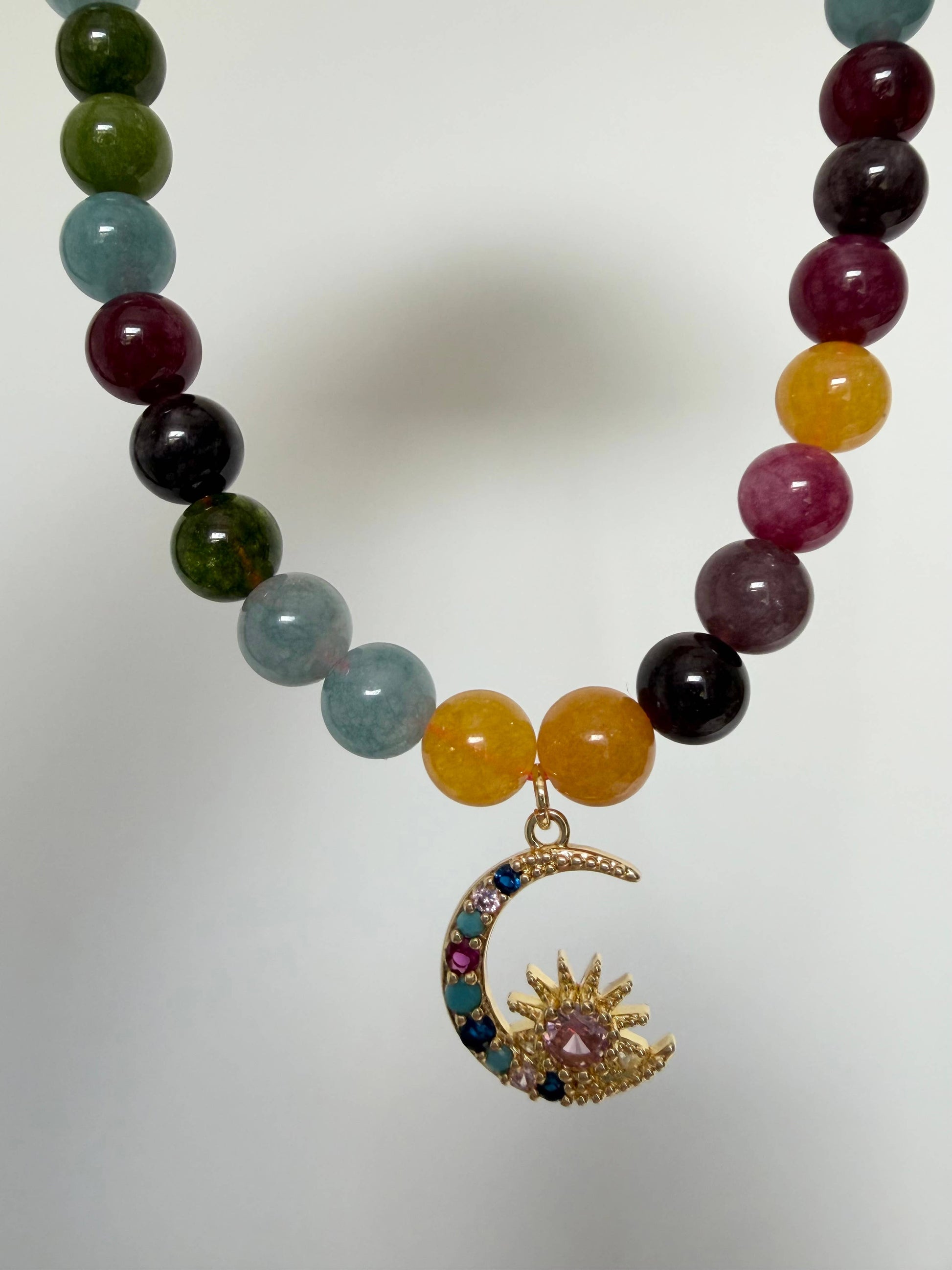 Close up of 18k gold plated moon charm with cubic zirconias on tourmaline necklace
