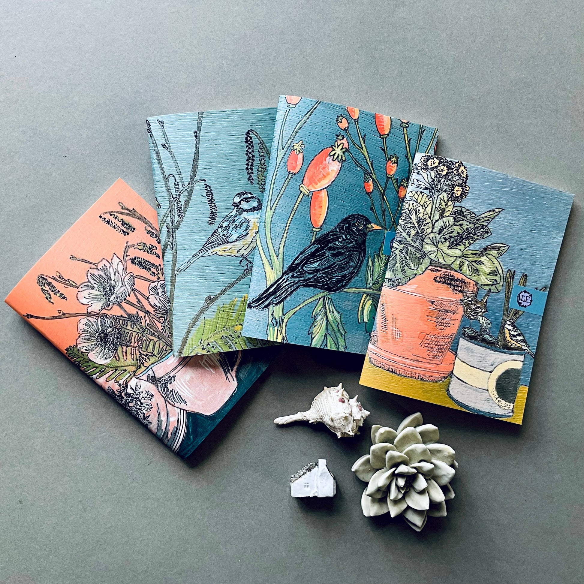 A selection of Lilly Faith's  A5 Notebooks, which are illustrated with birds and flora.
