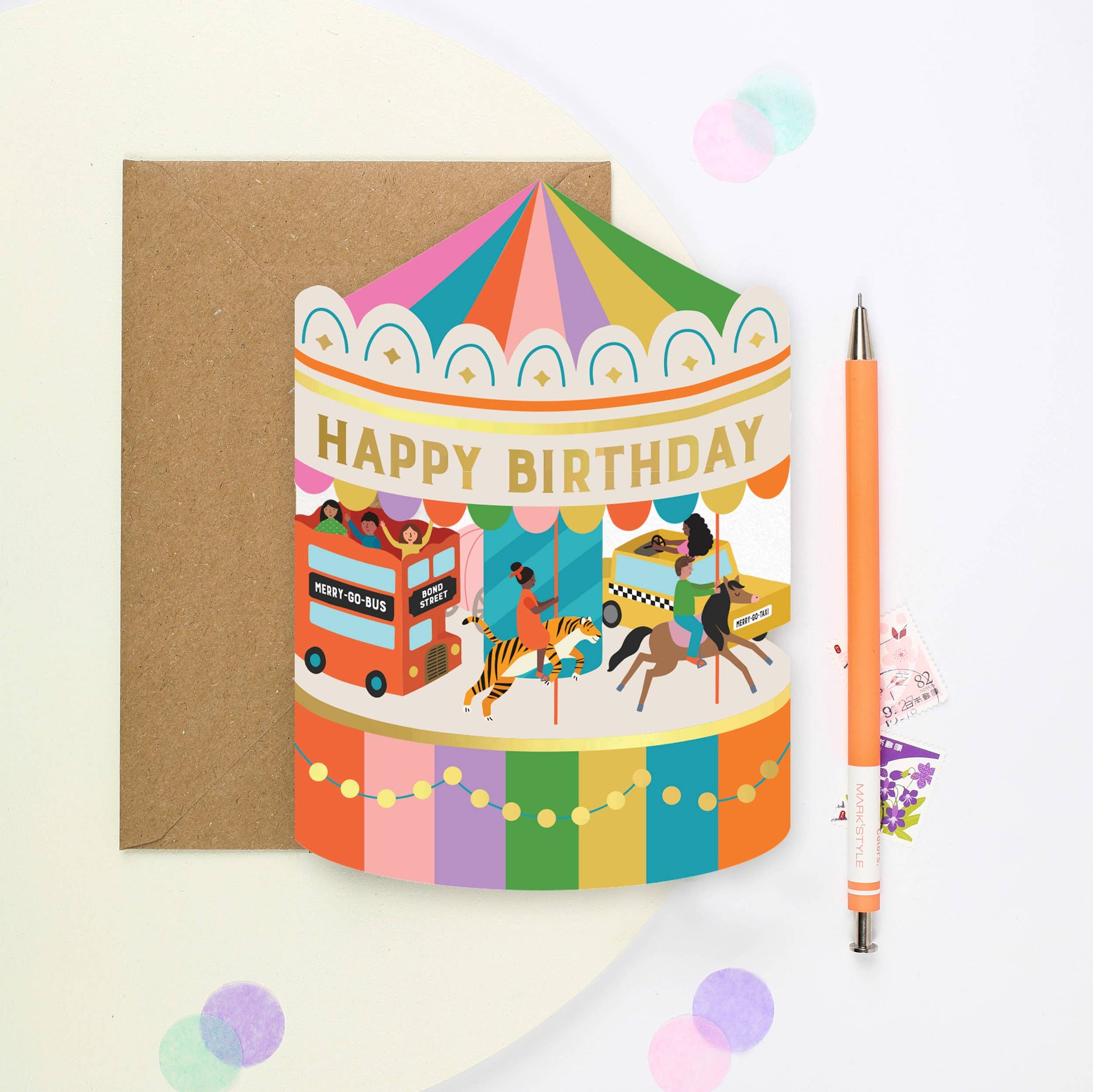 Step into a world of enchantment with our captivating Carousel Adventure Shaped Birthday Card. This unique greeting card, crafted in the shape of a whimsical carousel, features delightful illustrations including a New York taxi, alongside a playful horse, a majestic tiger, and a charming red London bus. Gold foil accents embellish the card, featuring the heartfelt caption 'Happy Birthday,' complemented by twinkling ‘gold foil’ lights adorning its base.