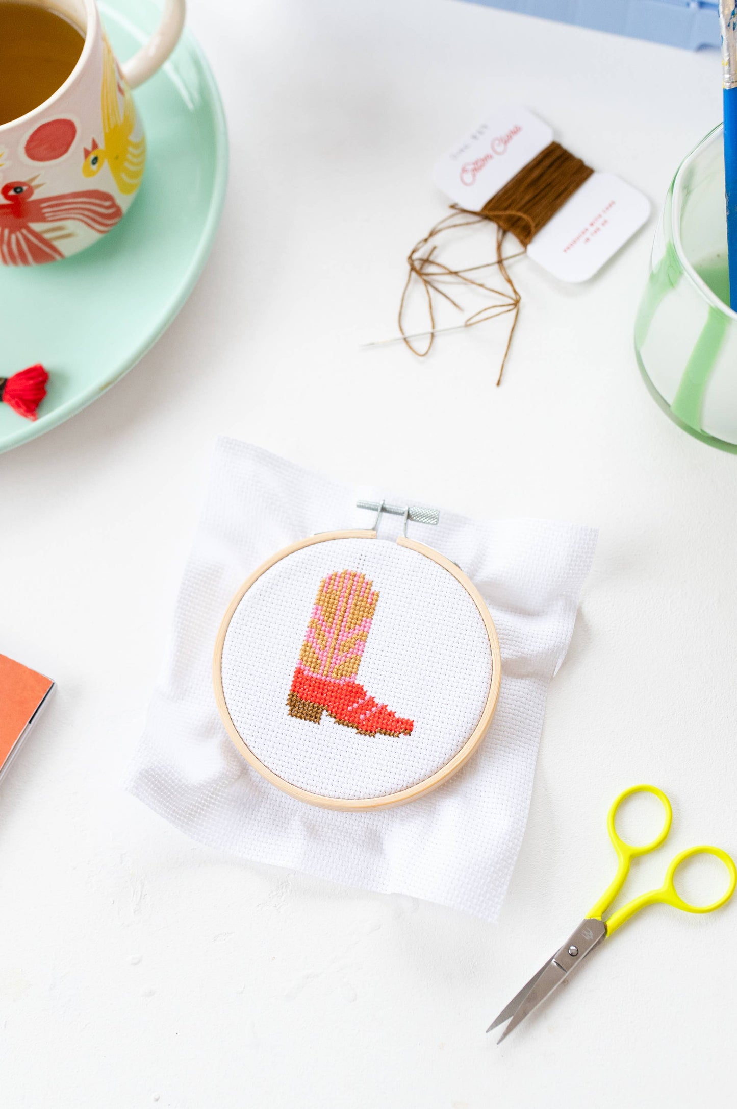 Stitched cowboy boot craft project on coloured aida