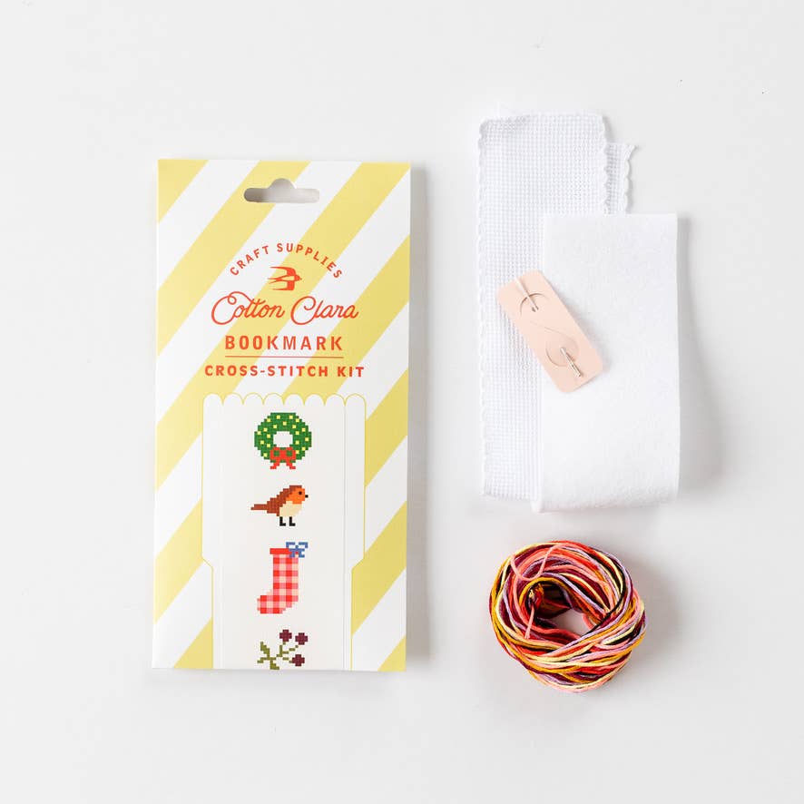 Close-up of hand-stitched Christmas wreath and present on bookmark