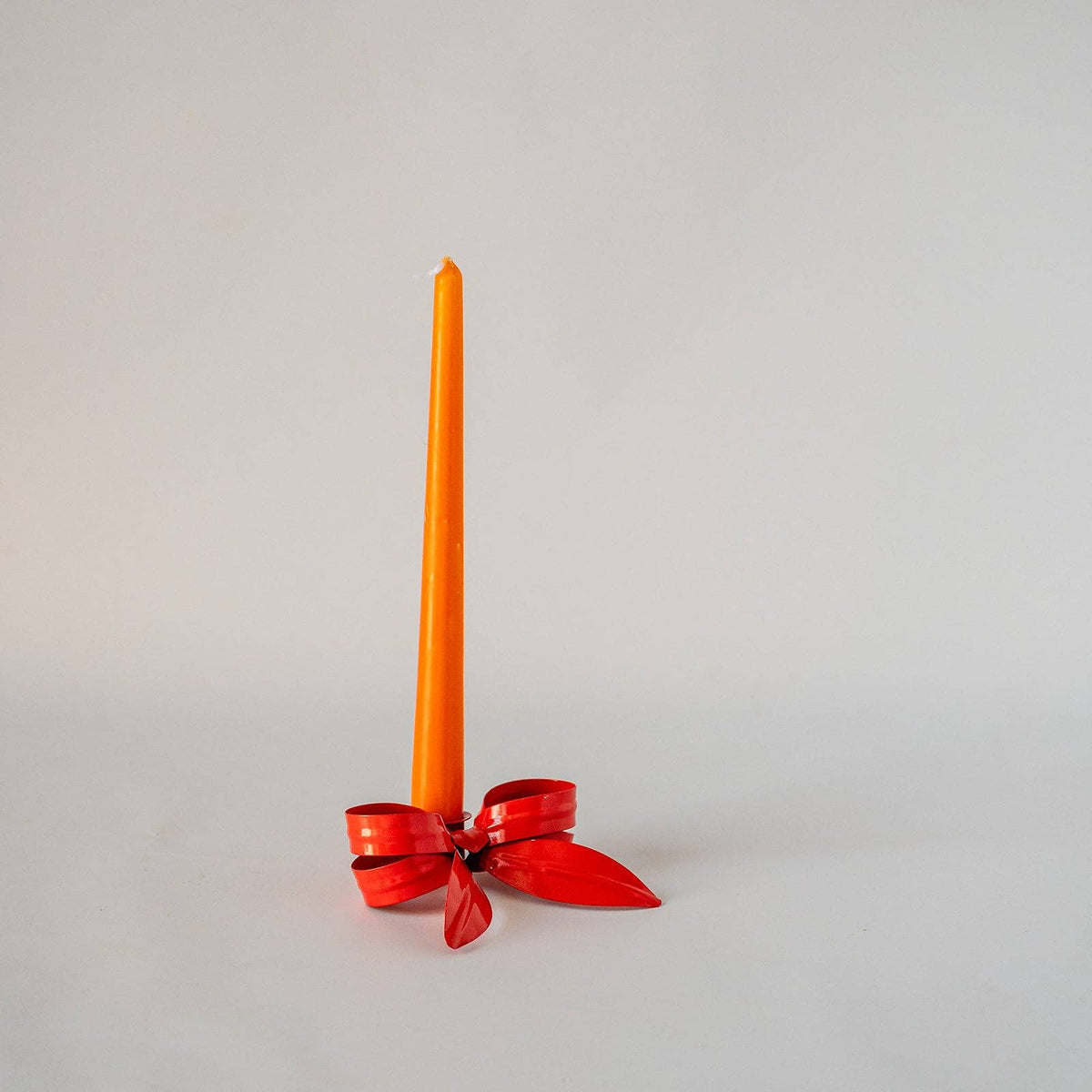 Ribbon Bow Candle Holder in Pomegranate on a styled table