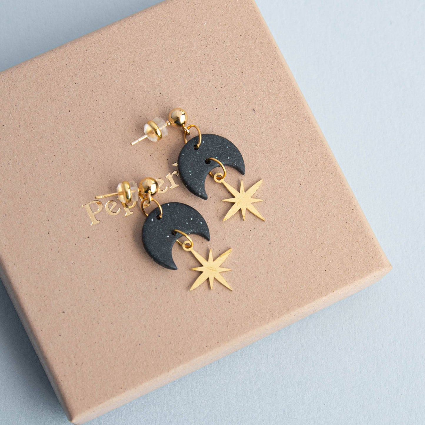 Close-up of Midnight Black Celestial Gold Star Drop Earrings, showing gold brass star and polymer clay texture.