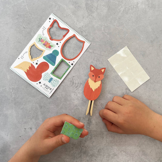 Child's hands assembling the Fox Peg Doll Craft Kit