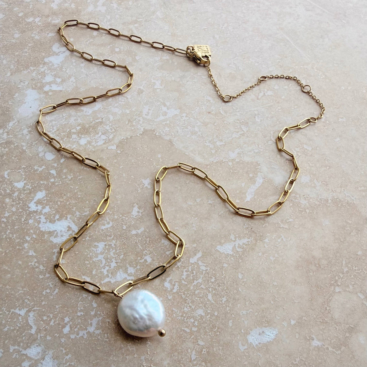 Close-up of unique baroque freshwater pearl pendant on a gold chain