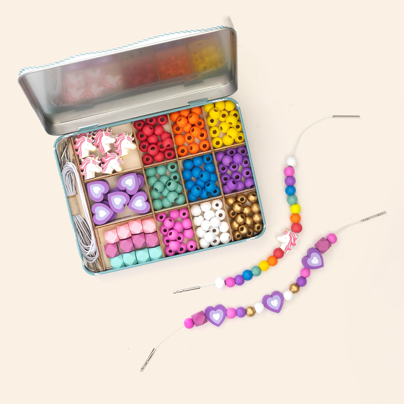 Colourful eco friendly wooden bead set with a tin and beaded necklace on a light background