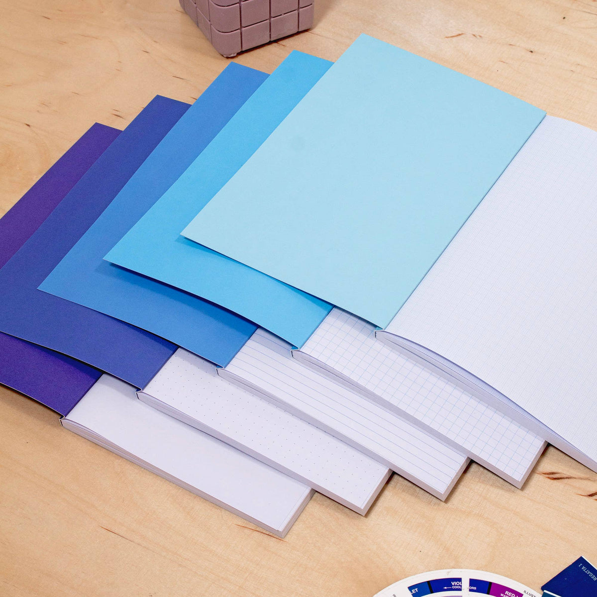 Side profile of sturdy card display box holding five notebooks